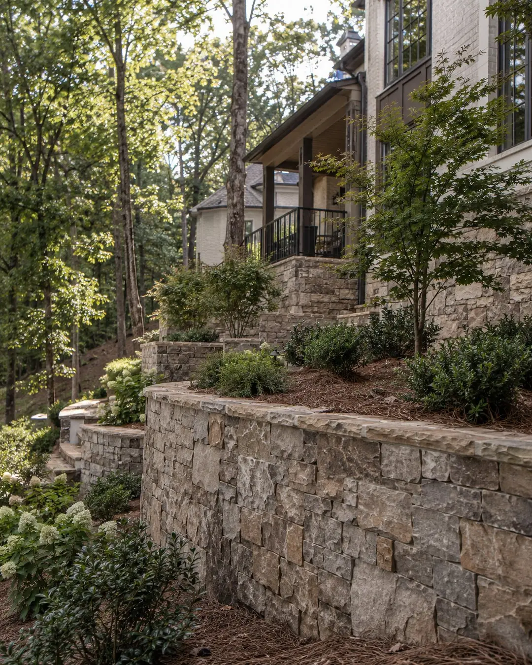 Stone retaining wall and construction on a wooded sloping lot